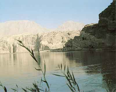 View from distance of the exterior of the Kumtura caves with the Muzat river in the foreground